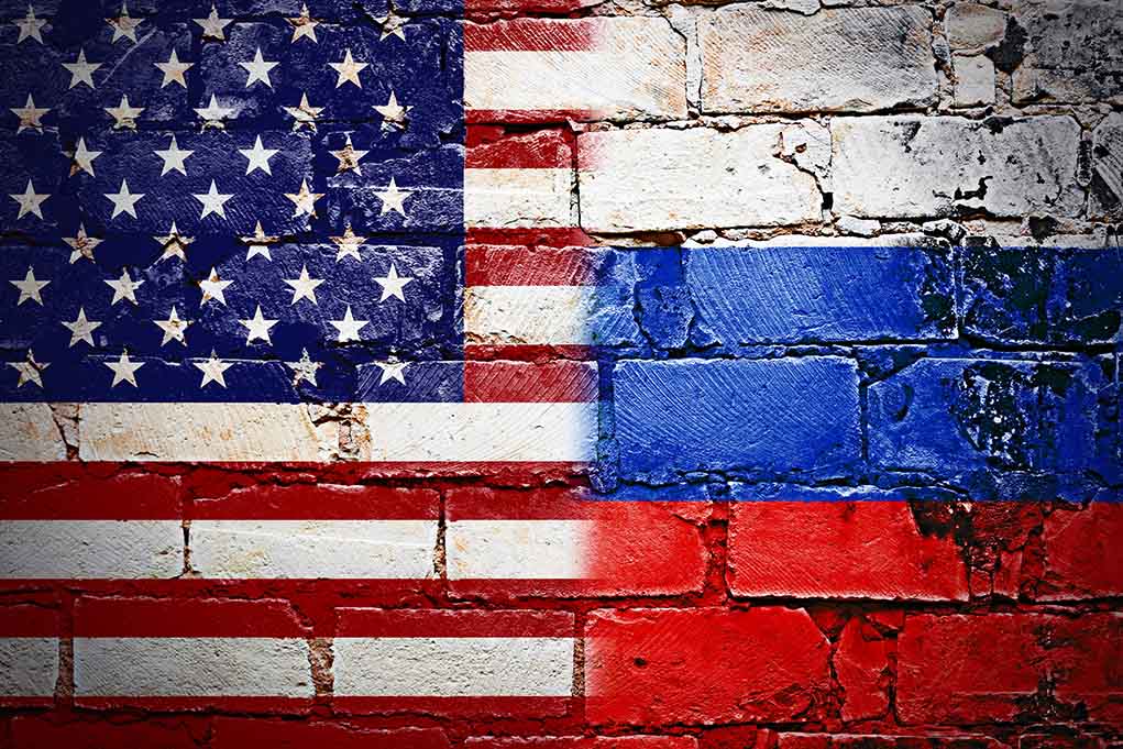 U.S. and Russian flags painted on a brick wall.