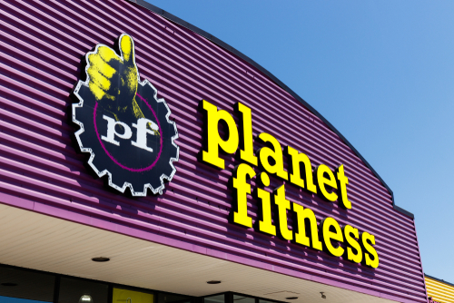 Planet Fitness gym sign against blue sky background.