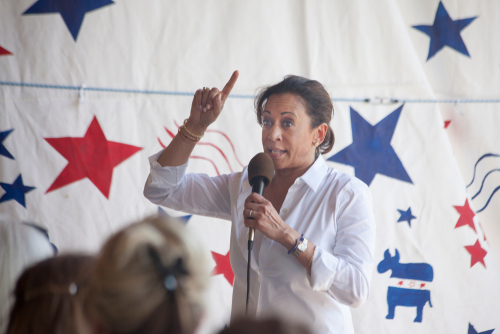 Unknown woman speaking and gesturing at a political event.