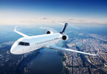 Airplane flying over a city with a river below.