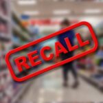 "Recall" sign on blurred supermarket background.