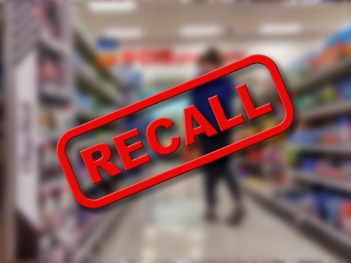 "Recall" sign on blurred supermarket background.