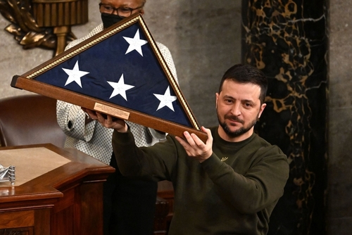 Man holding folded American flag in wooden case.