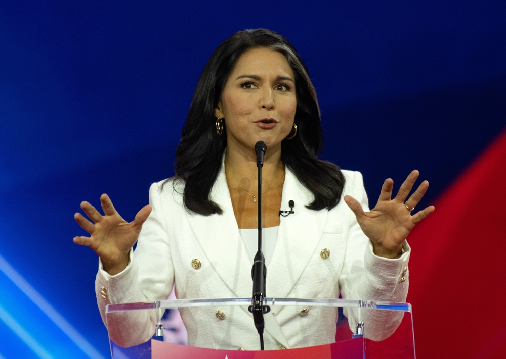 Person speaking at a podium with hands raised