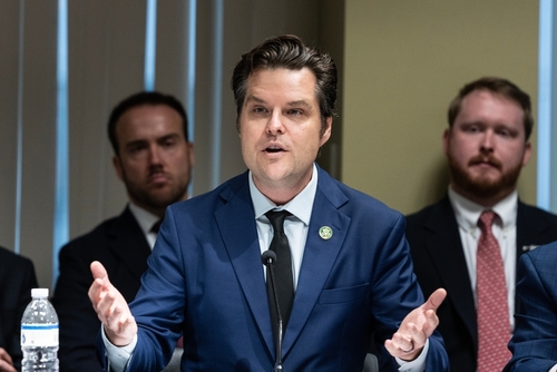 A man in suit speaking at a meeting.