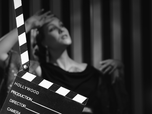 Black and white scene with clapboard and performer.