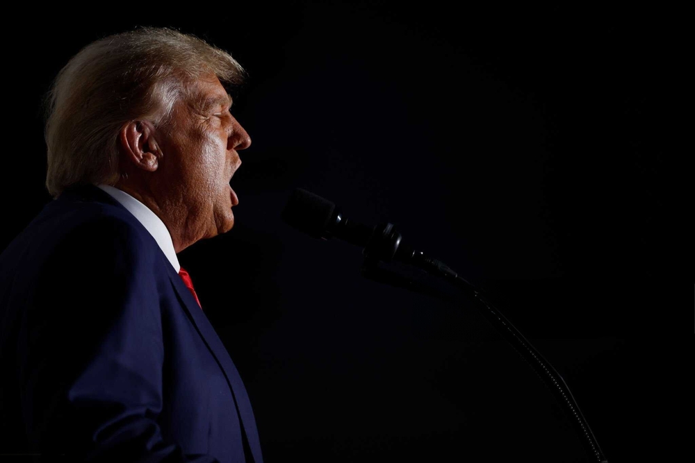 Man speaking into a microphone in the dark