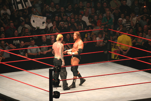 Wrestlers facing off in a ring at a match.