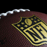 Three-Time Super Bowl Champion DEAD at 68… Close-up of football with NFL logo.