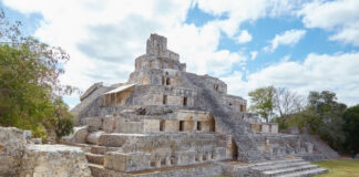 Ancient stone pyramid structure with stairs under a blue sky.