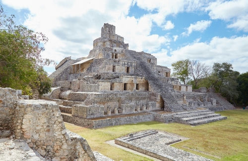shutterstock_2246953355.jpg Ancient stone pyramid structure with stairs under a blue sky.