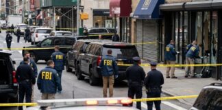 FBI agents and police officers at a crime scene with police tape