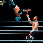 Wrestling Star ARRESTED—Industry Looks the Other Way… Two wrestlers mid-match, one performing an aerial move.