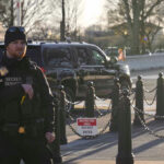 Secret Service agent standing near restricted area sign.