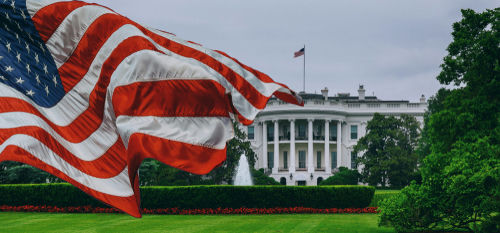 shutterstock1062500954-2jpg American flag waves before the White House on a cloudy day