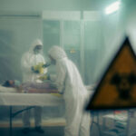 Ebola RISING: Rubio’s America-First Gamble… Two scientists examining a patient with biohazard sign visible.