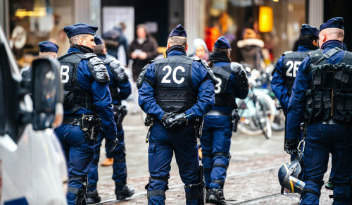 shutterstock_1052970863 Police officers in uniform gather on a city street