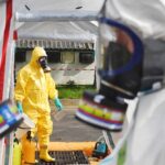 Emergency responders in hazmat suits preparing for a situation