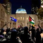 Texas Democrat Pitches Shocking ‘Zionist Camp’?! Crowd of individuals holding flags during a nighttime protest