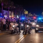 Massive Evacuation Sparks Fear of ‘Blast Zone’ Looters… Police officers managing a crowd on a busy street at night