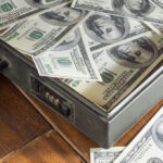 Open briefcase filled with one-hundred-dollar bills.