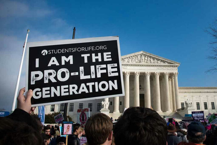 1638391450 Person holds Pro-Life Generation sign at protest.