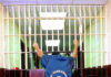 ICE Flags 1998 Fugitive In Teen Rape Case Person grabbing jail cell bars in St. Clair County.