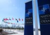 Russia’s Shadow War Tests NATO NATO flags displayed at the headquarters under a clear blue sky
