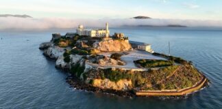 Aerial view of Alcatraz Island surrounded by water and fog