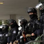 Group of police officers in riot gear standing in formation