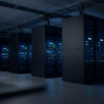 Rows of illuminated server racks in a dark data center