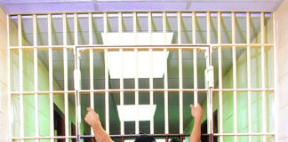 Person grabbing jail cell bars in St. Clair County.