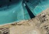 Iran Strikes Ignite Gulf Panic Satellite view of coastal industrial complex with turquoise water