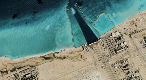 2523824585 Satellite view of coastal industrial complex with turquoise water