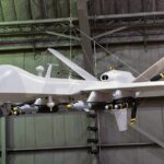 Homeland Lockdown: FCC Targets Drone Arteries military drone with missiles suspended in a hangar