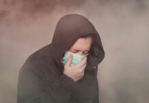 See The World’s Dirtiest Air Person with hood and mask coughing in foggy setting.