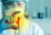 California’s Food Additive Crackdown Hits Hard Scientist holding a test tube with red liquid in a laboratory setting
