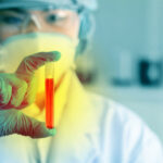 California’s Food Additive Crackdown Hits Hard Scientist holding a test tube with red liquid in a laboratory setting