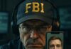 FBI agent holding a phone displaying a man's face