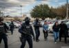 ICE agents conducting an arrest in a parking lot
