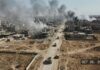 Drone Barrage Rattles Moscow’s Oil Lifeline Aerial view of a war-torn city with smoke rising from buildings