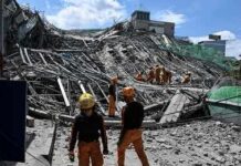 Tsunami Alert After Monster Quake Rescue workers survey collapsed building debris