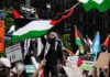 Iran Currency Collapse Sparks Nationwide Unrest Protesters wave Palestinian flags at a city demonstration