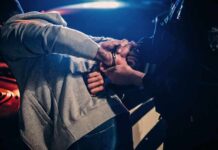 Top State Official BUSTED Outside McDonald’s Police officer handcuffing person at night by patrol car