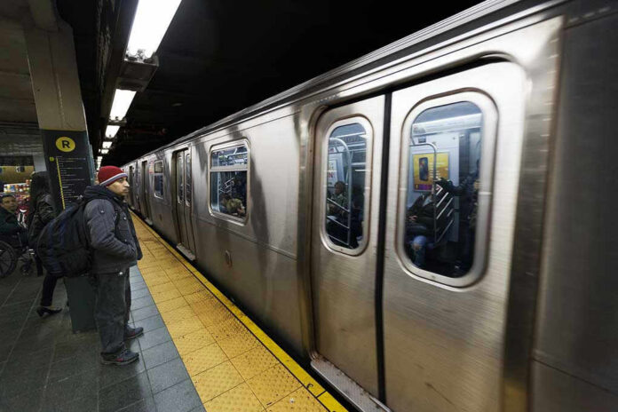 134560958 Subway train at platform with passengers inside and man waiting