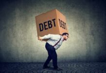 Trump Moves to Cancel $810 Million Man carrying a large box labeled debt on his back
