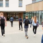Campus Crackdown: Is Violence Now ‘Acceptable’? Students with backpacks walking toward a school entrance