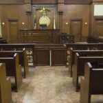 Texas Judge GUTS ATF Power Interior view of an empty courtroom with wooden benches and a judges bench