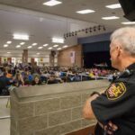 Trusted Officer, Unthinkable Allegations security officer overseeing a crowded school cafeteria