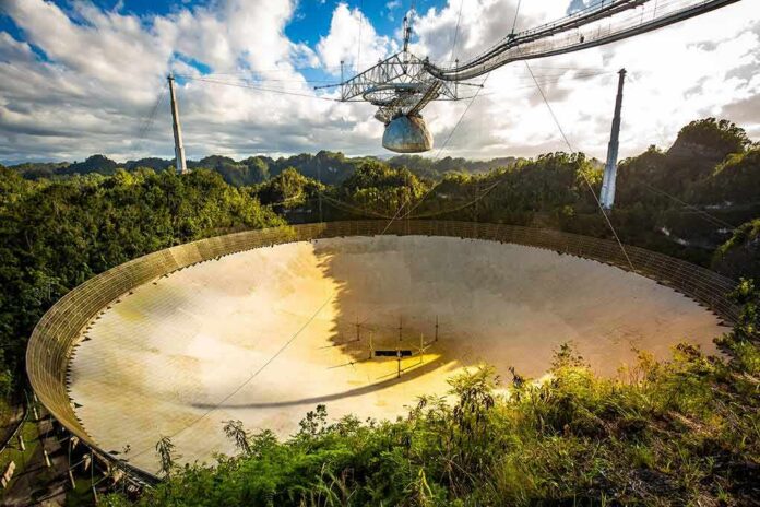 shutterstock_1263118534 Arecibo radio telescope dish in a lush valley